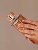 Holding Mismatch Bronze glass bottle with faux leather cover and rose gold lid