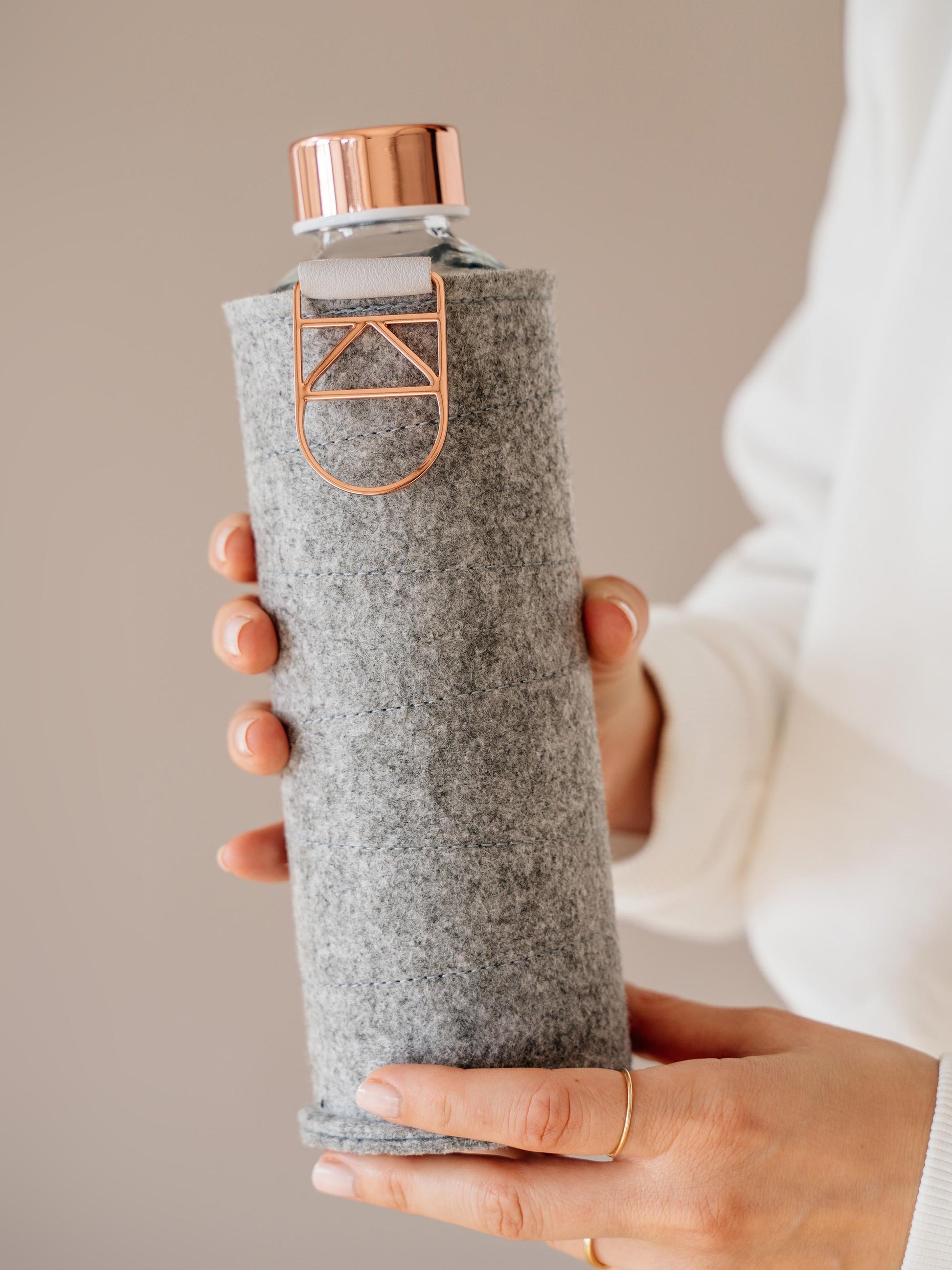 Holding Mismatch Rose Gold glass bottle with felt cover 