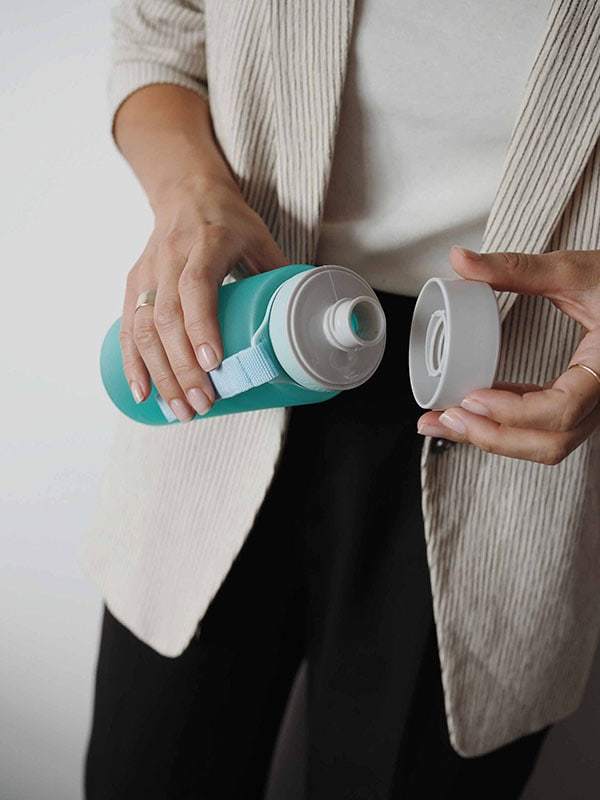 EQUA BPA FREE water bottle, Ocean, business woman holding water bottle in hands, minimalistic design, no motif, blue color