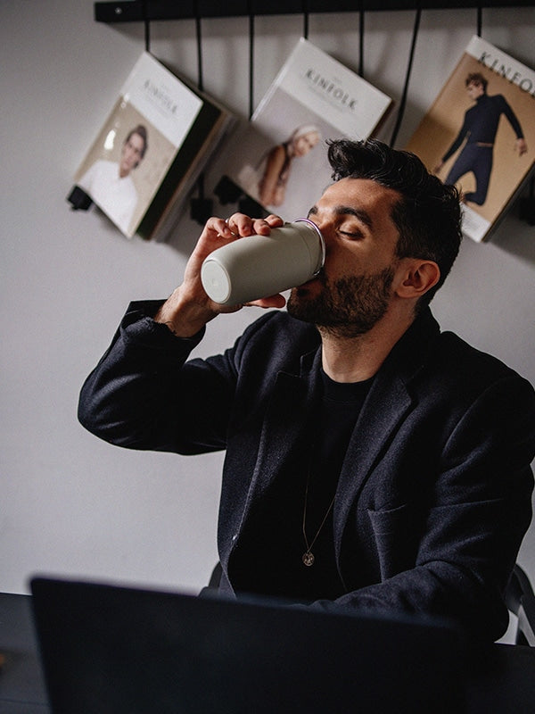 Man drinking from EQUA Cup Grey in a caffee environment