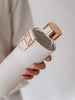 EQUA Sage reusable glass water bottle with white and grey faux leather cover and golden lid and metallic handle