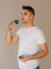 EQUA BPA FREE water bottle, Plain Blue, handsome young man drinking water from the bottle, minimalistic design, no motif, dark blue color