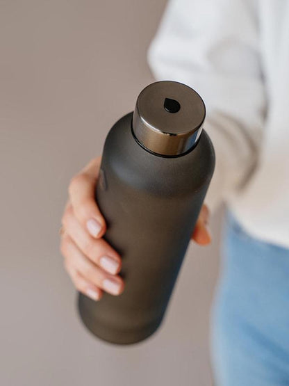 Ash glass water bottle with black drop logo and matte silk finish. Perfect for the office and every day use.