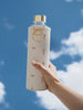 EQUA glass water bottle Playa with golden details with sky background