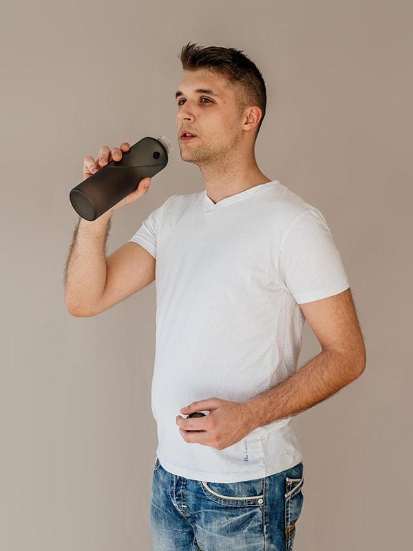 Man drinking from black water bottle, matte finish on the bottle and drop logo, minimalistic design Ashy water bottle by EQUA